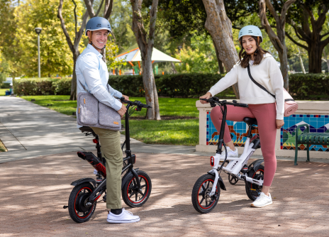 Two people with electric bikes in a park setting