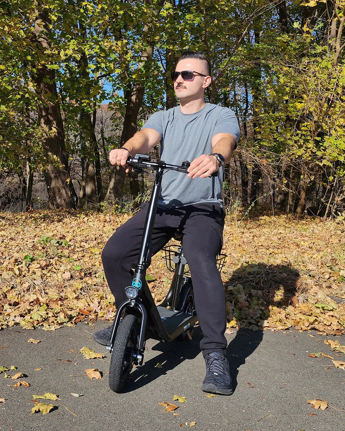 Man riding Gyroor C1 electric scooter on a forest trail in autumn