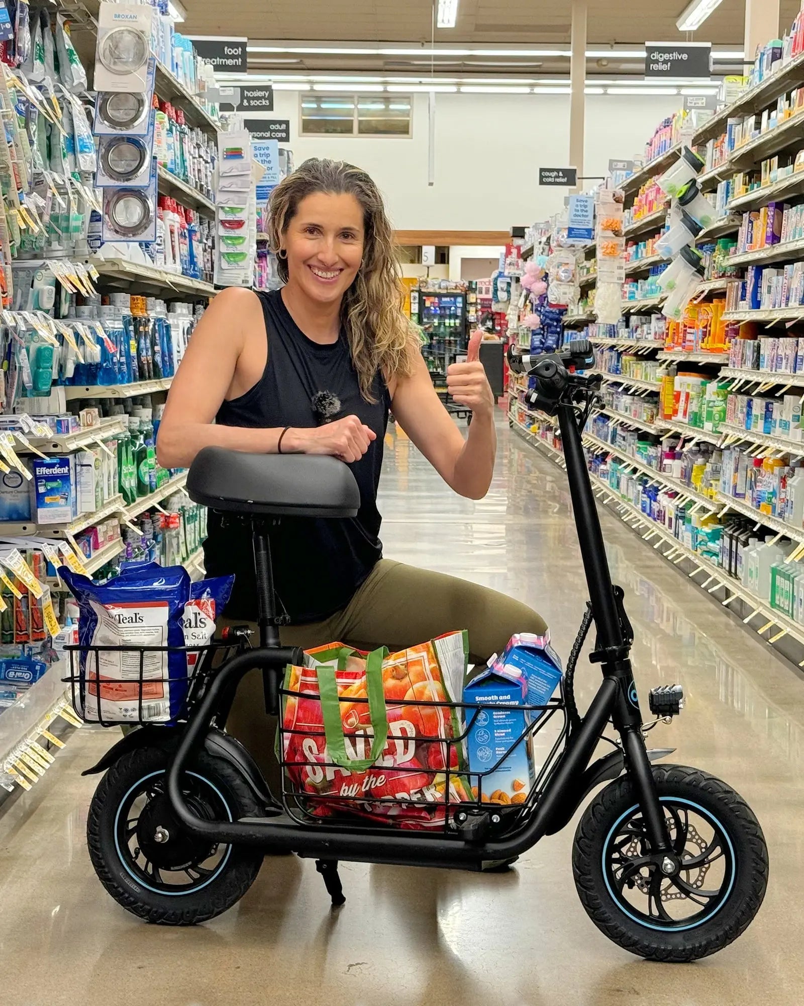 woman shopping with seated electric scooter in grocery store